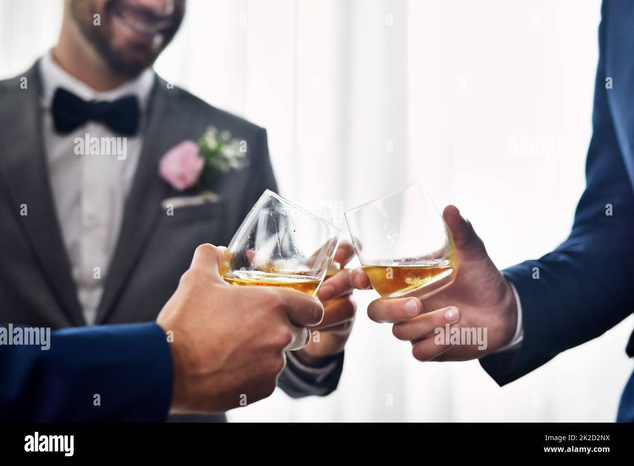 Mes copains m'accueillent dans la vie mariée. Photo de deux groommen méconnaissables partageant un toast avec le marié le jour de son mariage. Banque D'Images