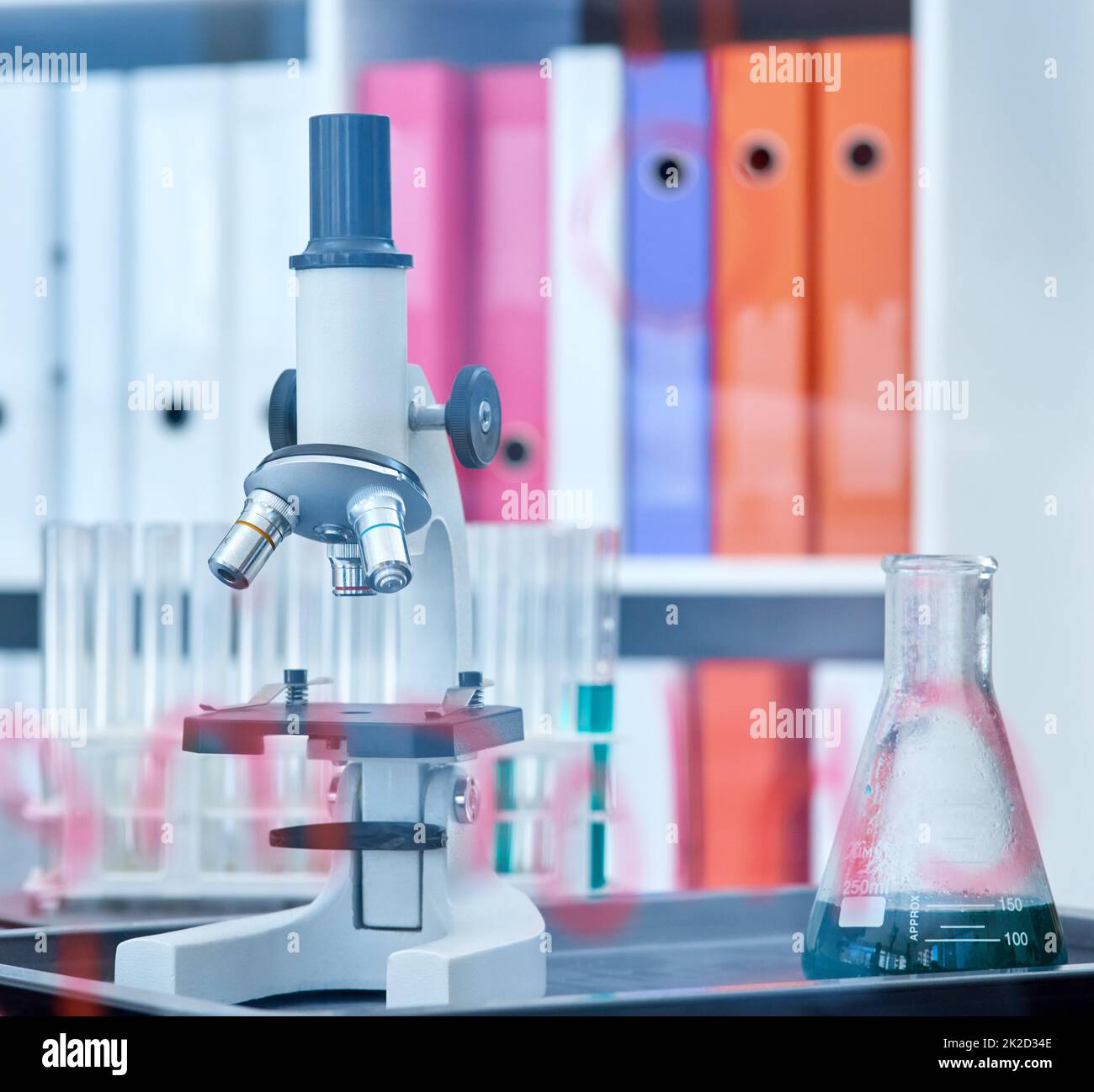 Chaque expérience favorise la découverte et l'apprentissage. Gros plan d'un microscope et d'un bécher dans un laboratoire. Banque D'Images