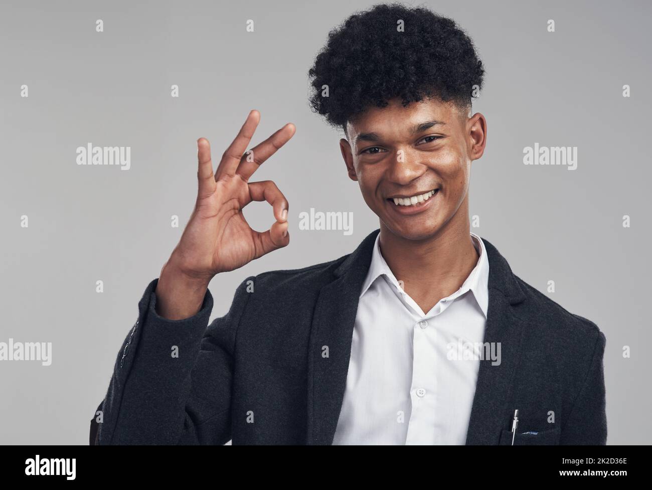 En trois... deux... un. Photo studio d'un jeune homme d'affaires montrant un geste de main correct sur fond gris. Banque D'Images