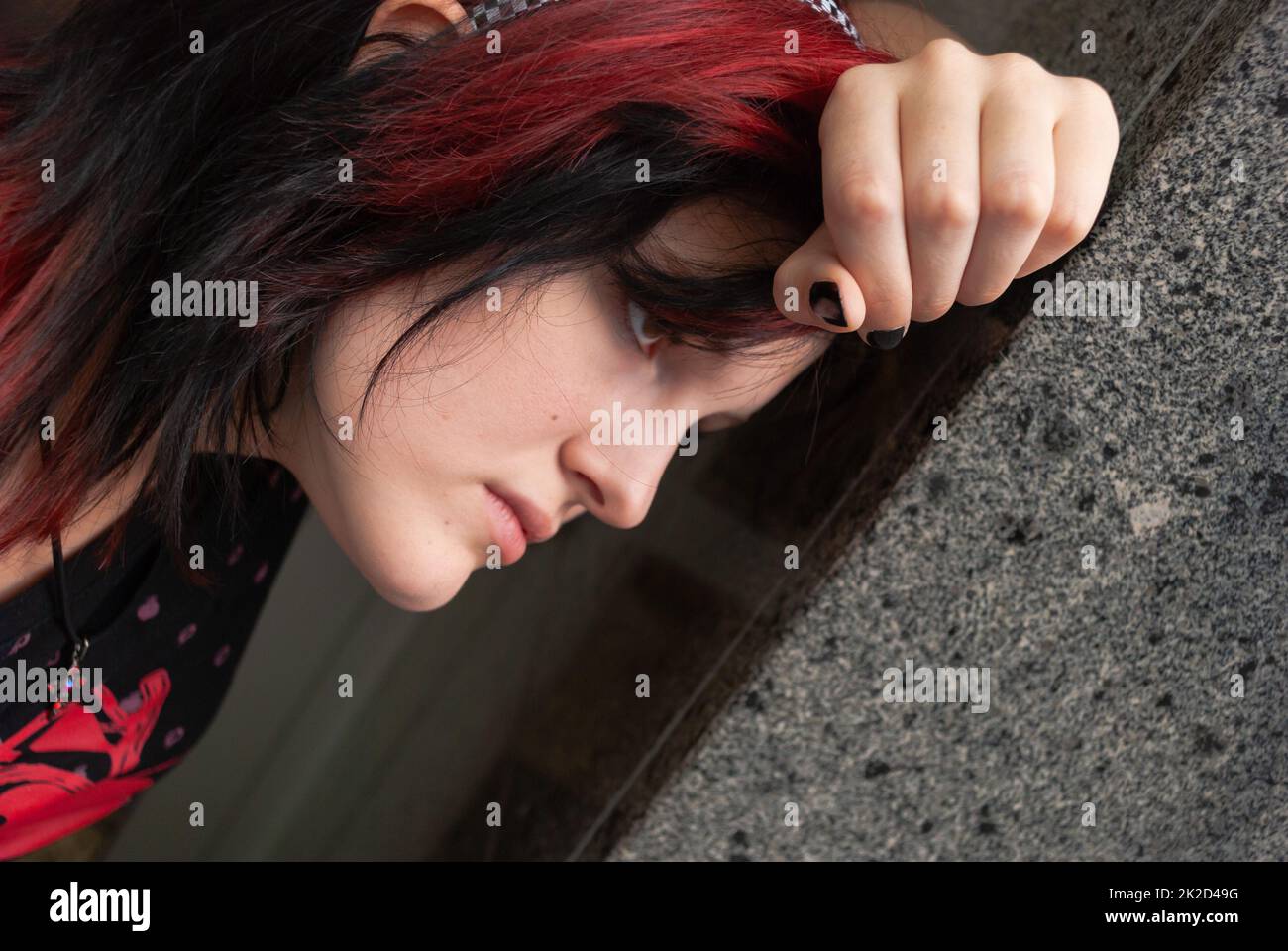 Punk emo girl, jeune adulte avec des cheveux rouges noirs Banque D'Images