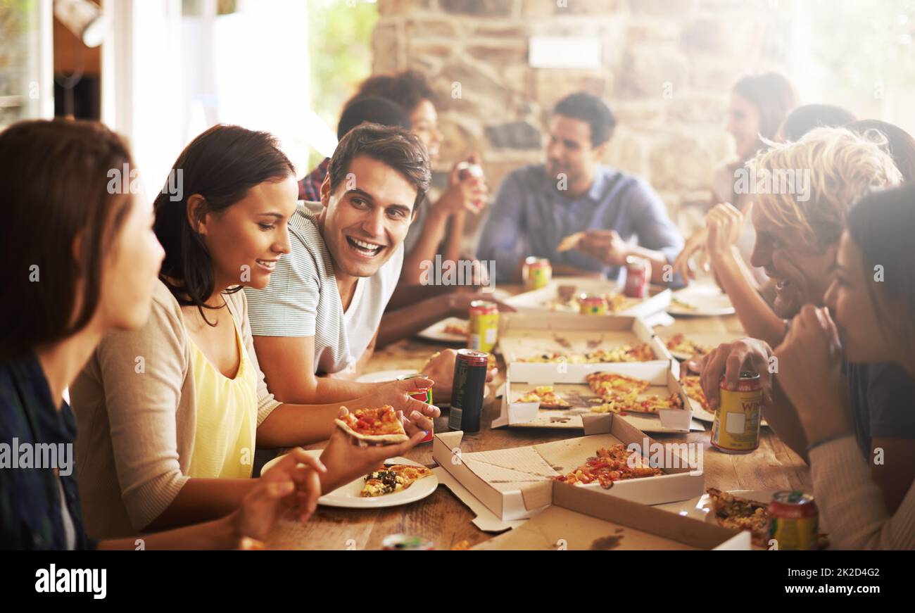 Super amis et nourriture. Photo d'un groupe d'amis en train de savourer une pizza ensemble. Banque D'Images