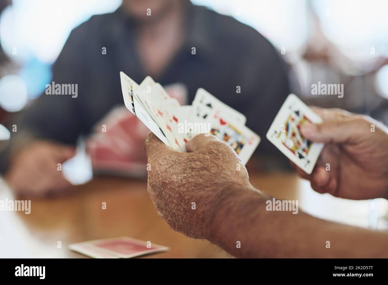 Je ne joue pas ces mains bien. Plan court de personnes âgées jouant au poker dans leur maison de retraite. Banque D'Images