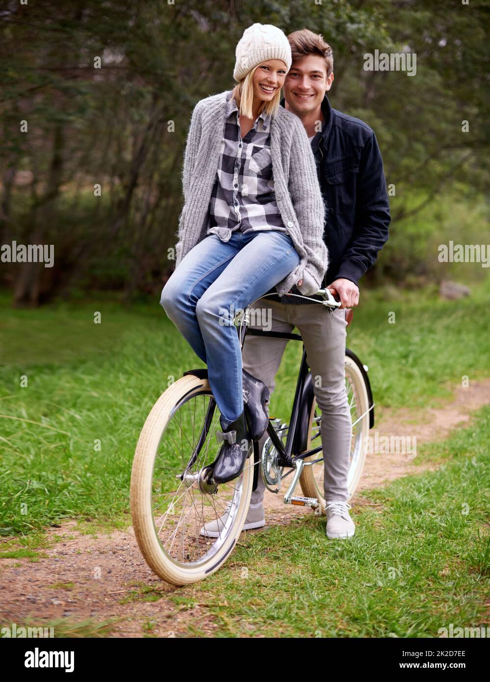 Donner un ascenseur à son amour. Un jeune couple qui profite d'une balade à vélo en plein air ensemble. Banque D'Images