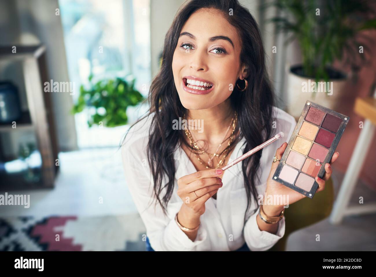 Cette palette est indispensable. Photo d'un influenceur enregistrant un didacticiel de maquillage pour son blog à la maison. Banque D'Images