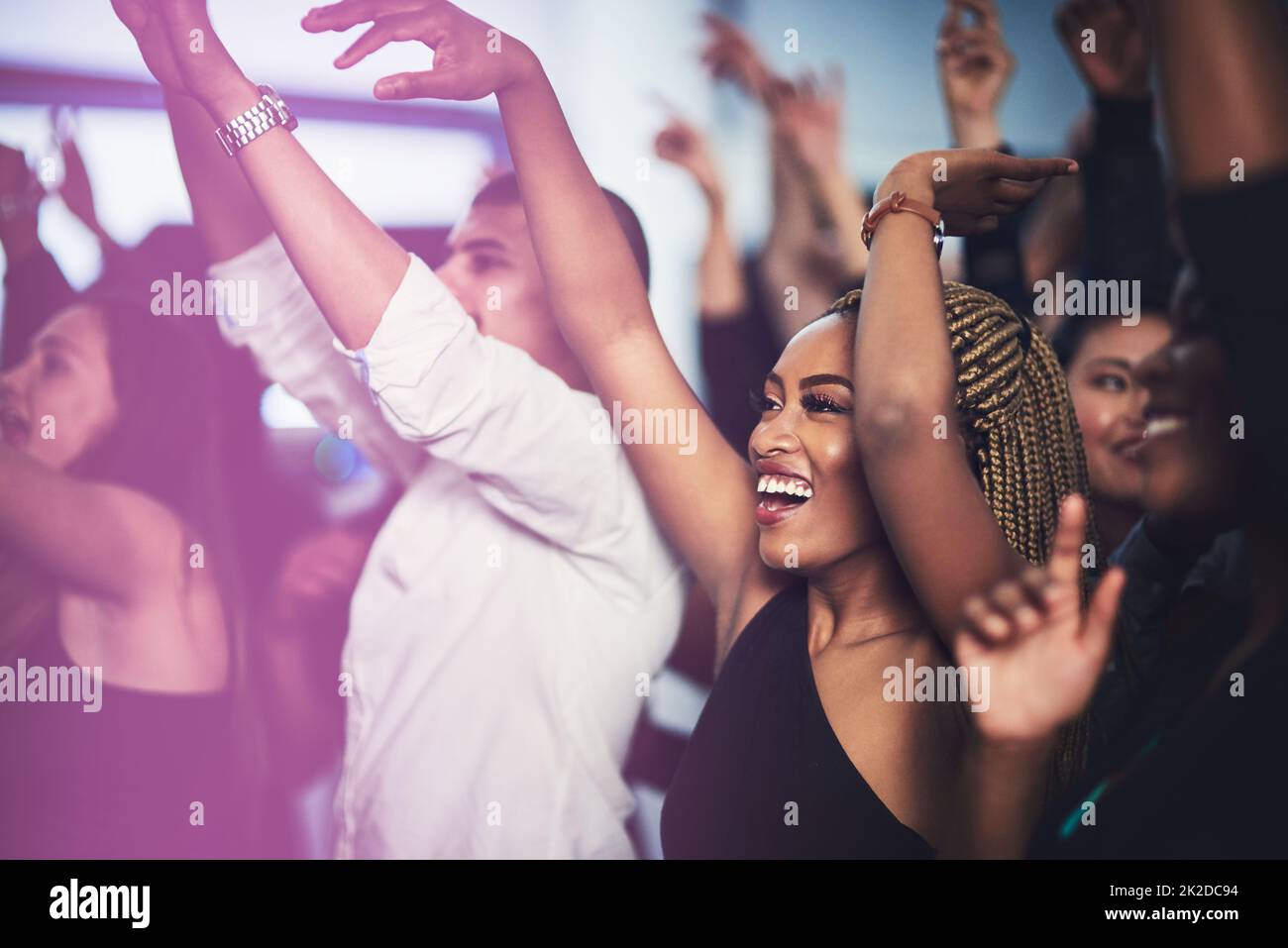 C'est ma chanson préférée. Photo courte d'une jeune femme attrayante qui applaudisse tout en se tenant debout dans la foule lors d'un concert la nuit. Banque D'Images