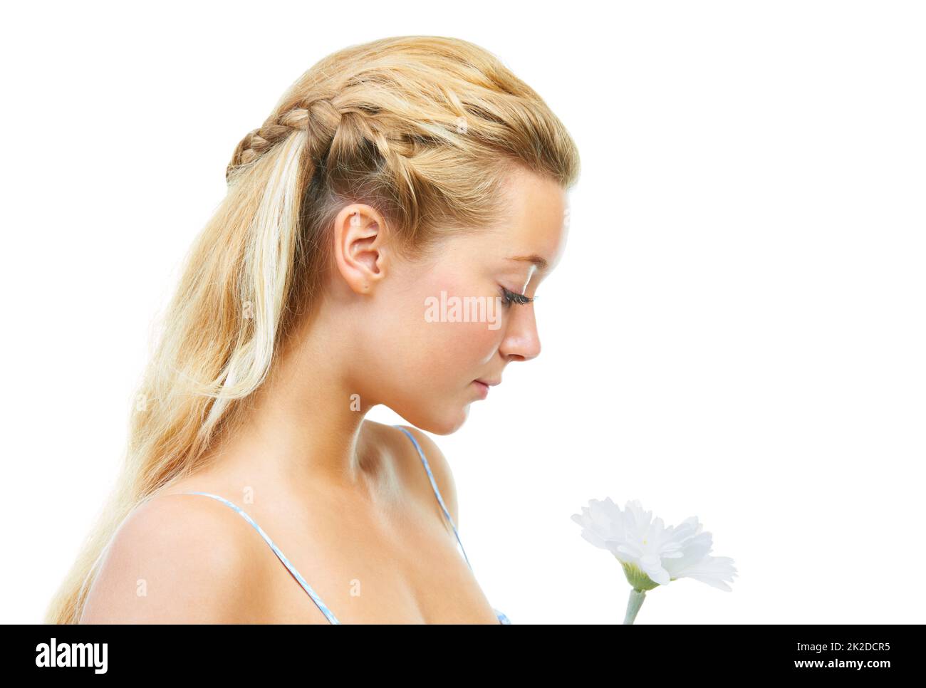 Parfait comme pétale de fleur. Photo studio d'une jeune femme tenant une fleur isolée sur blanc. Banque D'Images