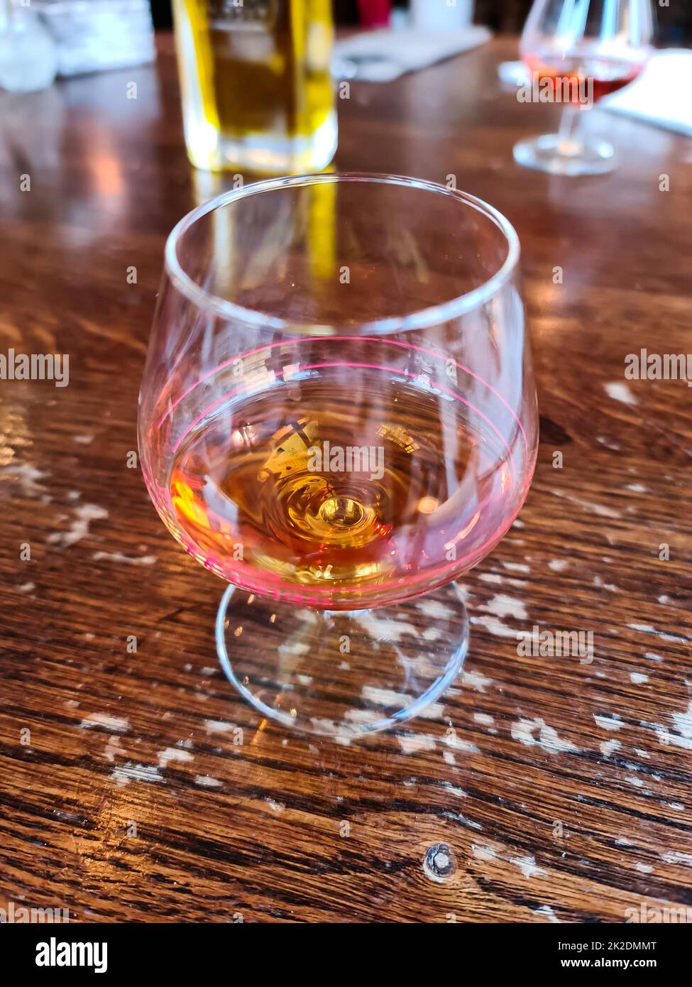 Un verre d'amaretto avec un fond doux sur une table en bois Banque D'Images