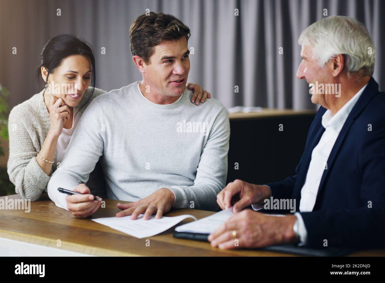 La sécurisation de votre avenir commence dès maintenant. Photo d'une réunion de jeunes couples avec un consultant mature. Banque D'Images