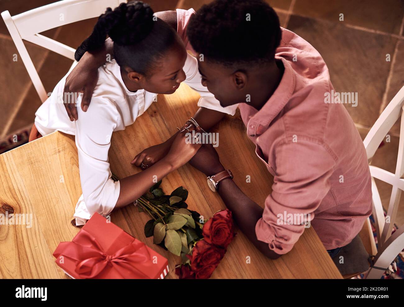 La Saint Valentin ne s'améliore pas. Photo en grand angle d'un jeune couple affectueux tenant les mains intimement lorsqu'il est assis dans sa cuisine le jour de la Saint-Valentin. Banque D'Images