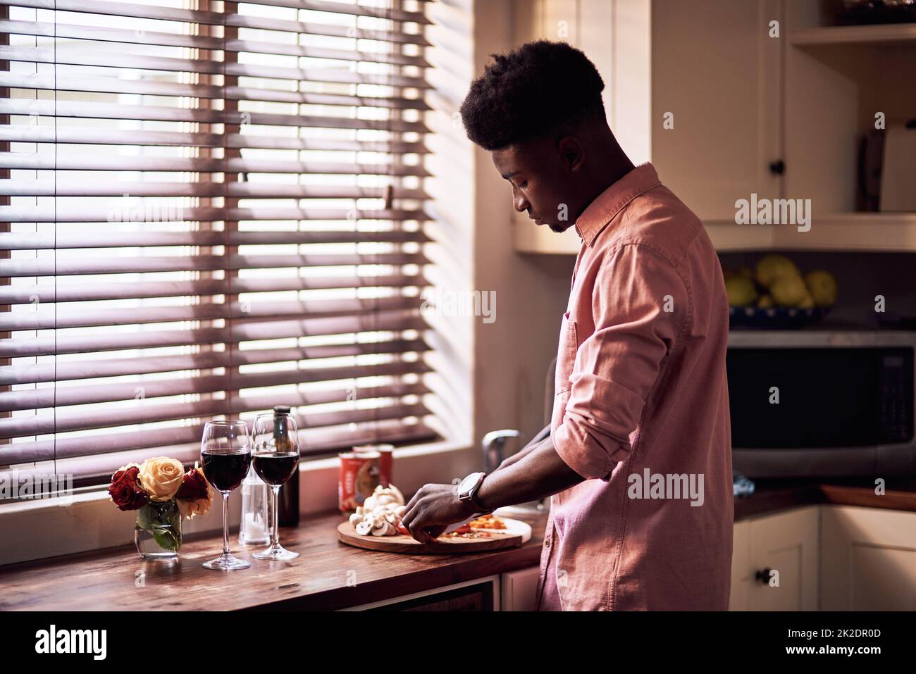 HES va gâcher sa femme aujourd'hui. Petit cliché d'un jeune homme romantique qui prépare un repas le jour de la Saint-Valentin à la maison. Banque D'Images