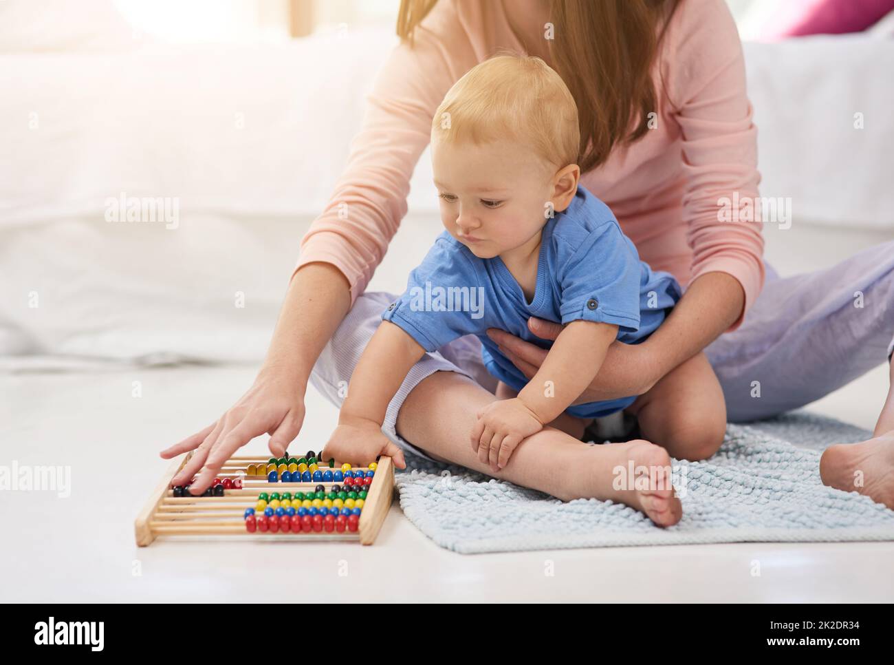 Maman et son mini mathématicien. Coupe courte d'une mère et de son bébé garçon comptant sur un abacus. Banque D'Images