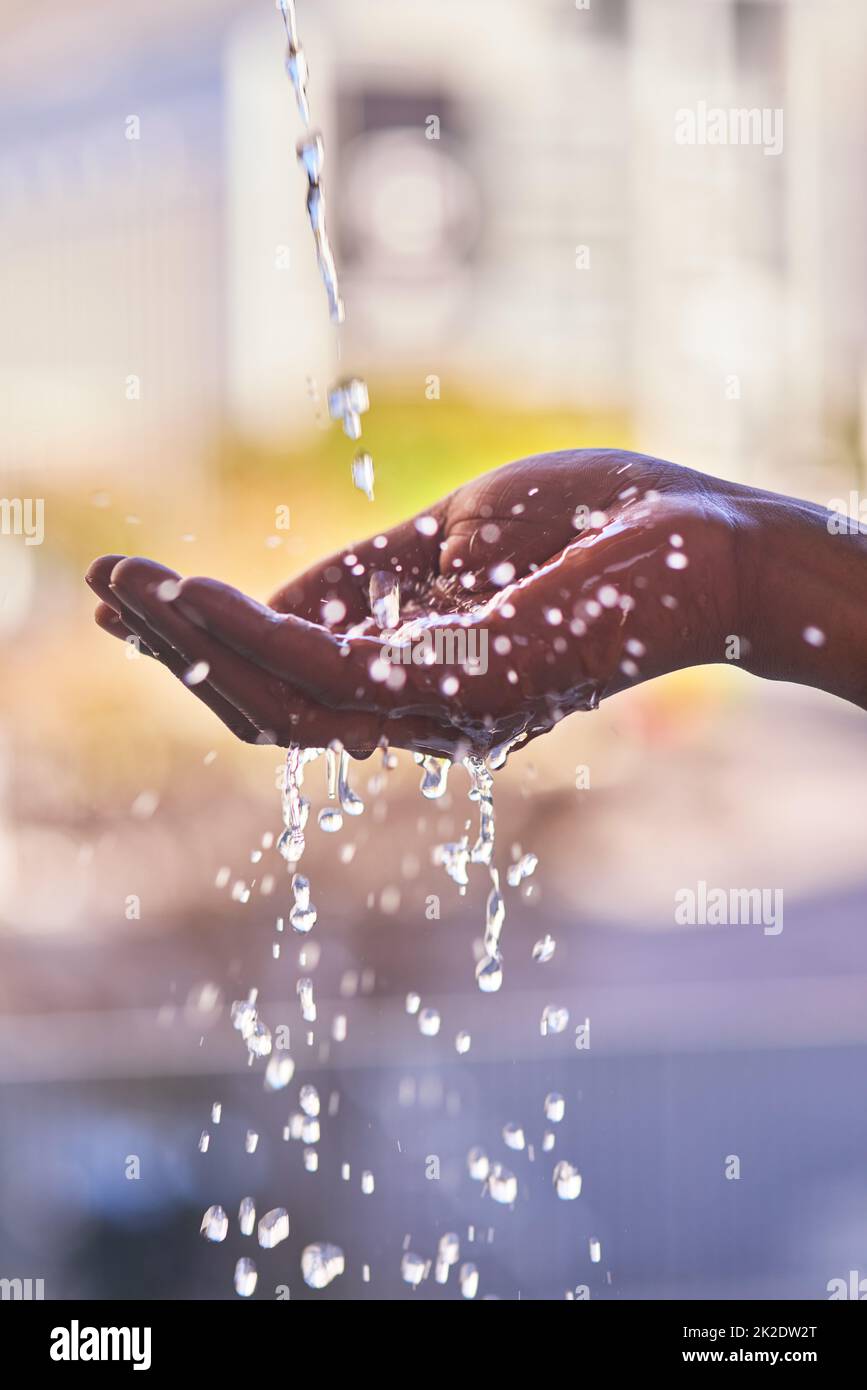 Là où il y a de l'eau, il y a la vie. Plan court d'un homme se lavant les mains avec de l'eau rafraîchissante à l'extérieur. Banque D'Images