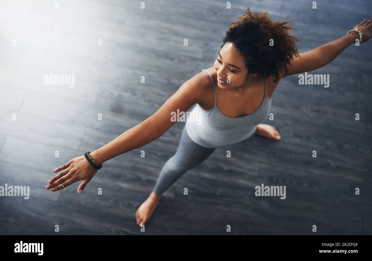 Pour rester en forme, vous devez vous étirer. Photo en grand angle d'une jeune femme pratiquant le yoga. Banque D'Images