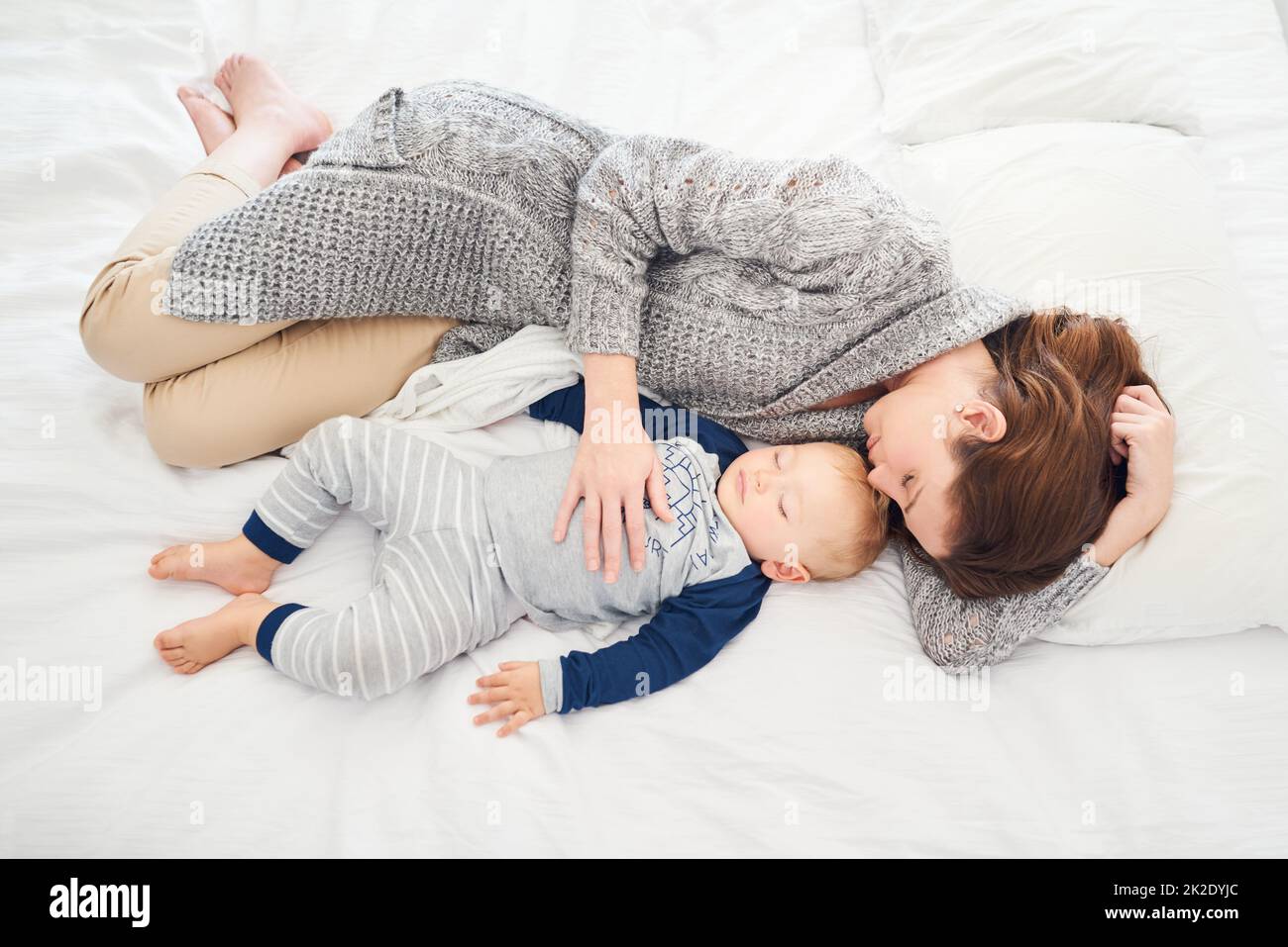 Des mamans se joignent à lui pour la sieste. Photo d'une mère et de son bébé garçon dormant ensemble à la maison. Banque D'Images