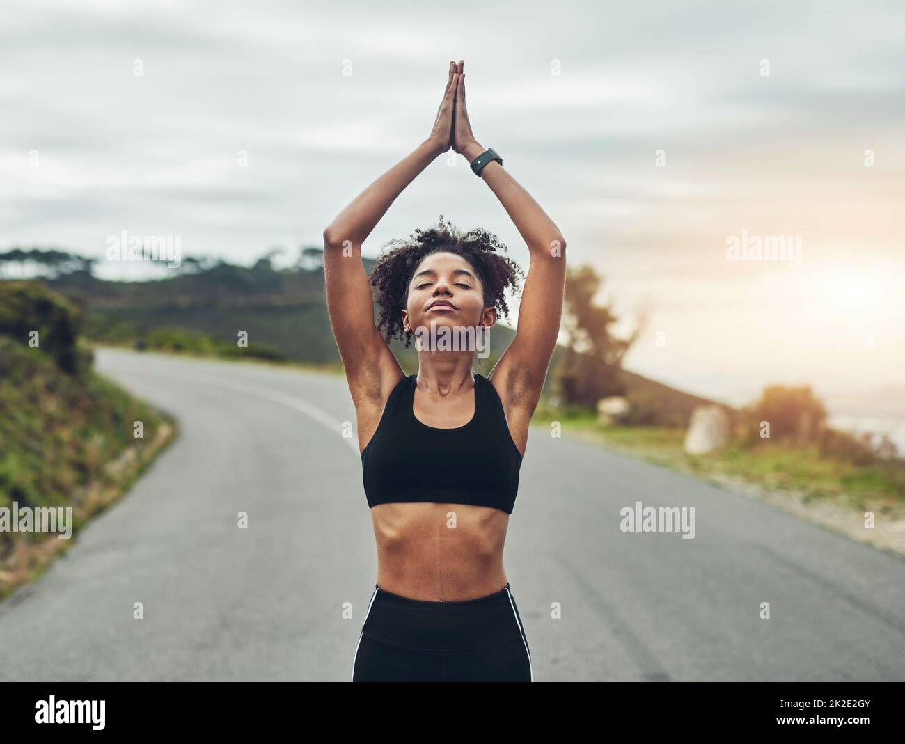Trouver l'équilibre. Photo courte d'une jeune sportswoman attirante méditant pendant son entraînement en plein air. Banque D'Images