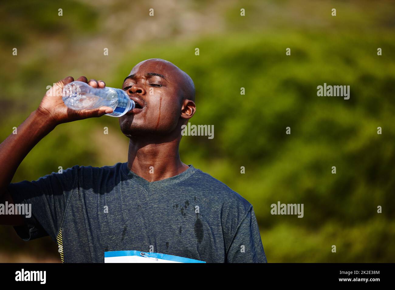 H2O - Un meilleur ami des coureurs. Photo d'un jeune homme qui boit de sa bouteille d'eau pendant une course. Banque D'Images