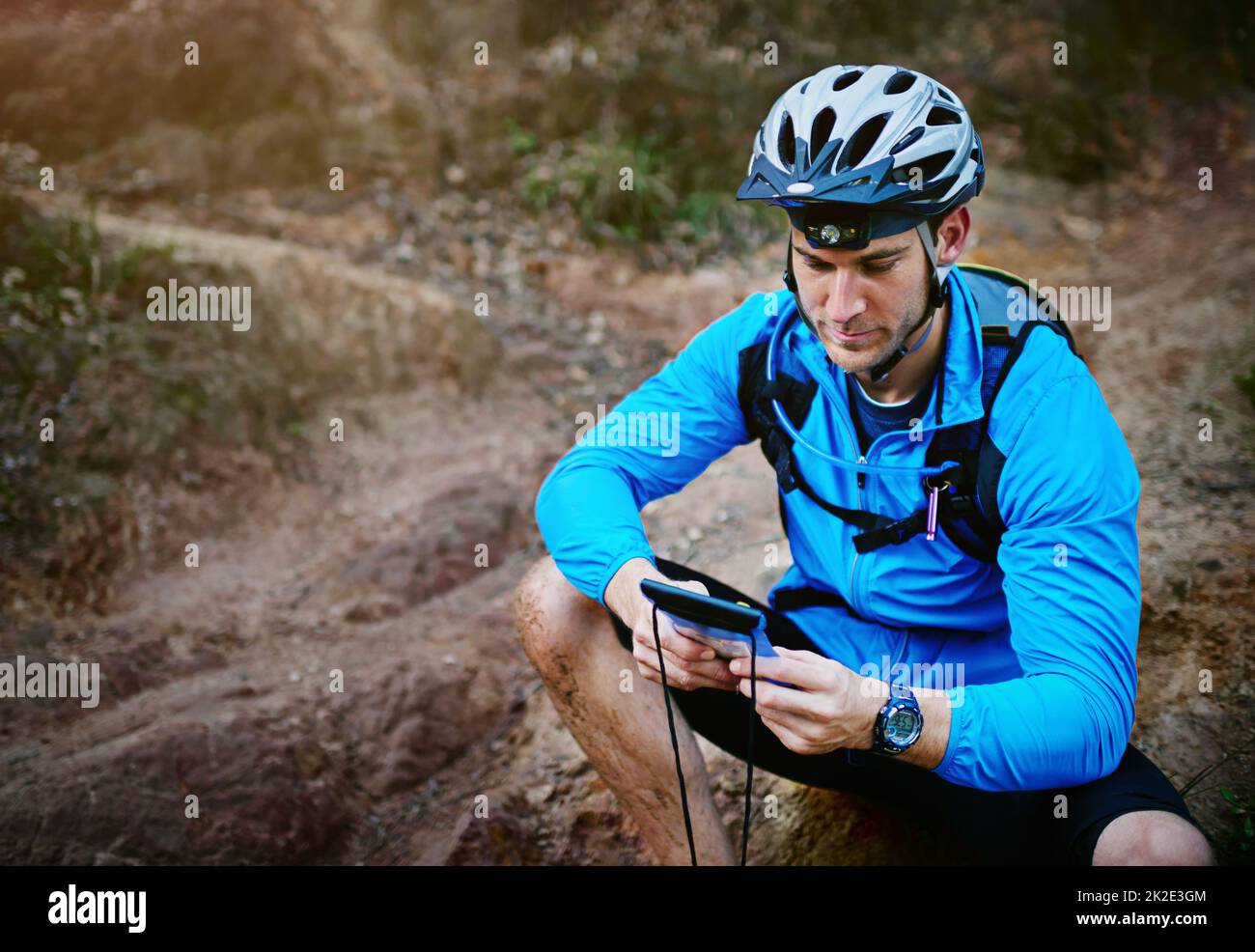 Vérifier sa position à l'aide du GPS de son smartphone. Prise de vue d'un cycliste à l'aide de son smartphone lors d'un trajet. Banque D'Images