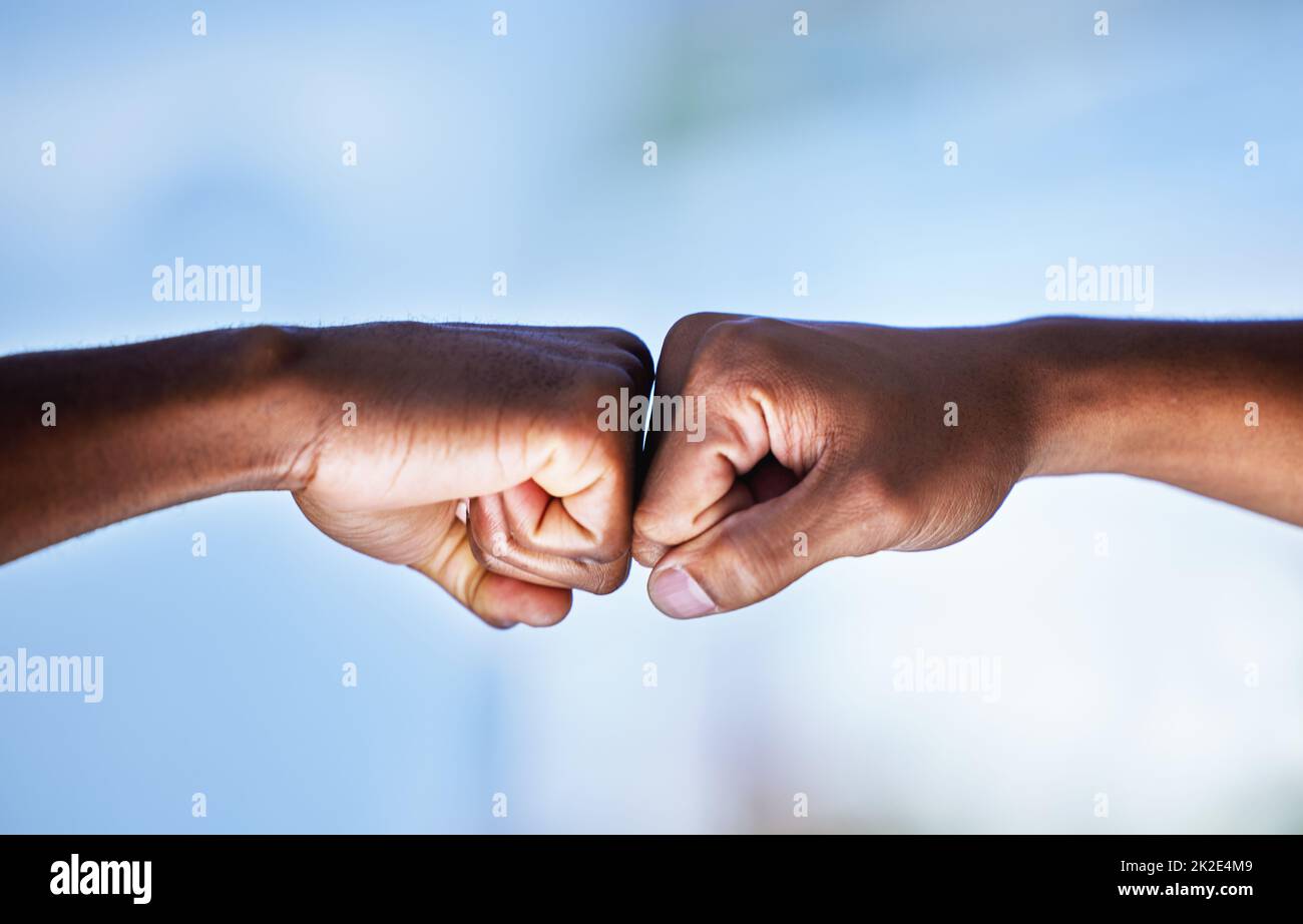 Le travail d'équipe nous fait gagner. Gros plan de deux hommes méconnaissables qui se cognent des poings. Banque D'Images