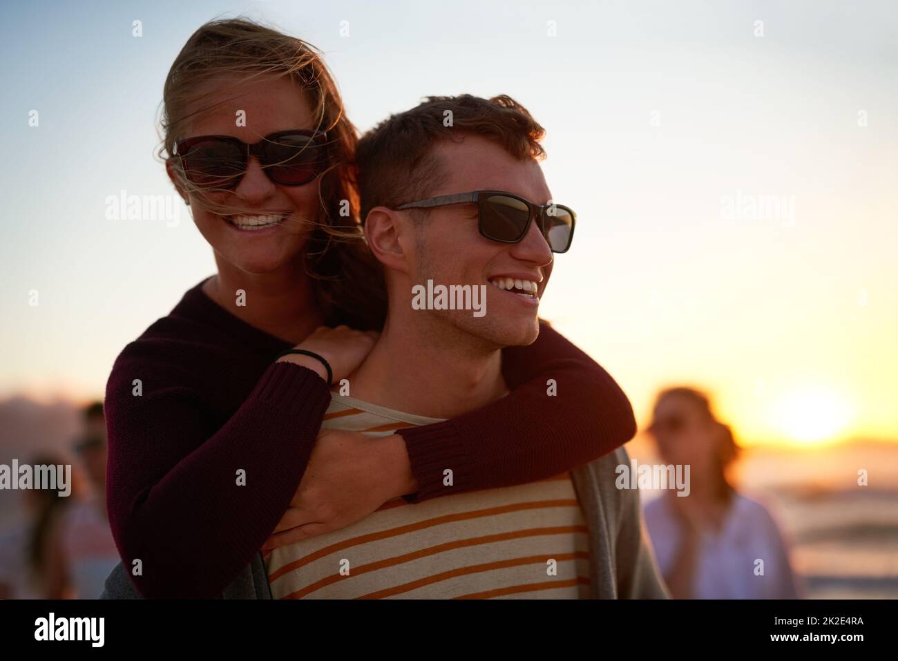 Je suis heureux quand je l'ai proche. Photo courte d'un jeune homme affectueux qui soutient sa petite amie sur la plage. Banque D'Images
