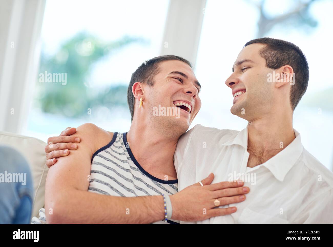 Notre maison est remplie d'amour et de rire. Photo d'un couple gay se détendant ensemble à la maison. Banque D'Images