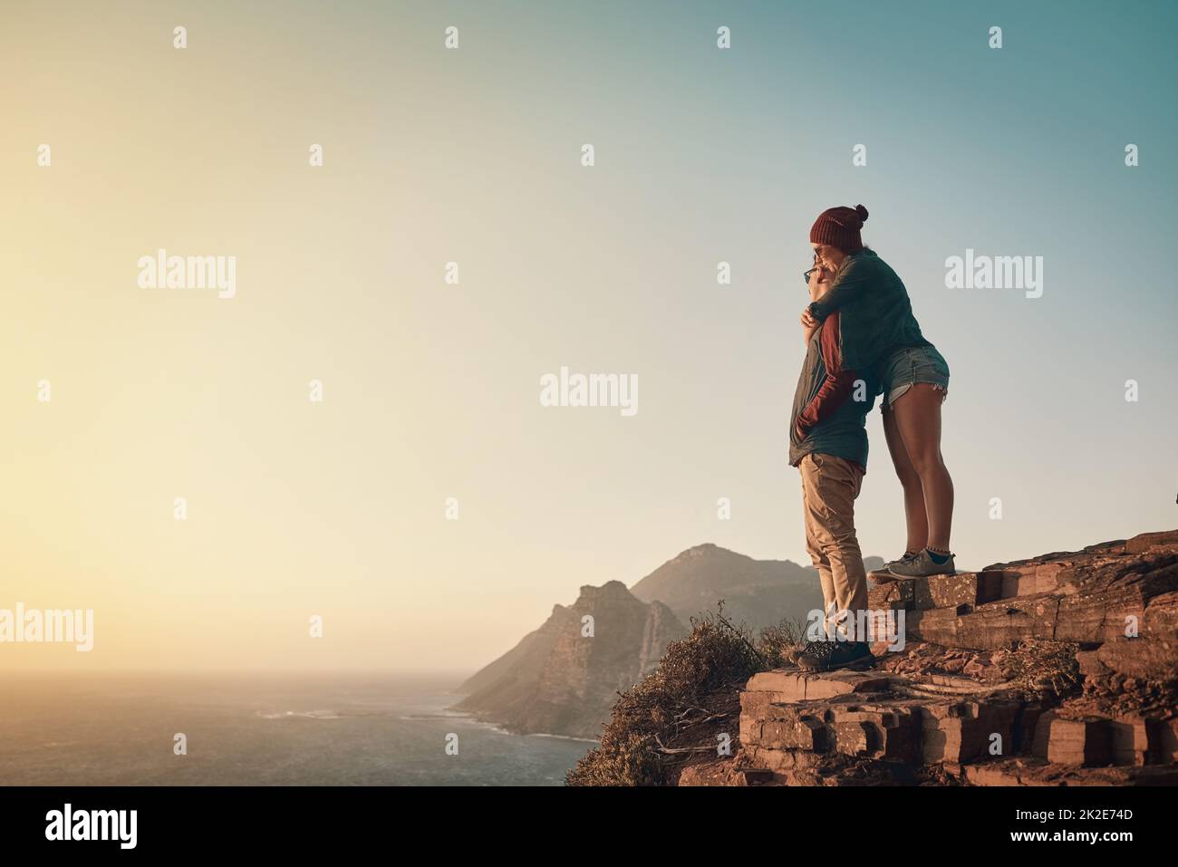 Cette vue est incroyable. Photo en longueur d'un jeune couple affectueux prenant la vue depuis un sommet de montagne. Banque D'Images