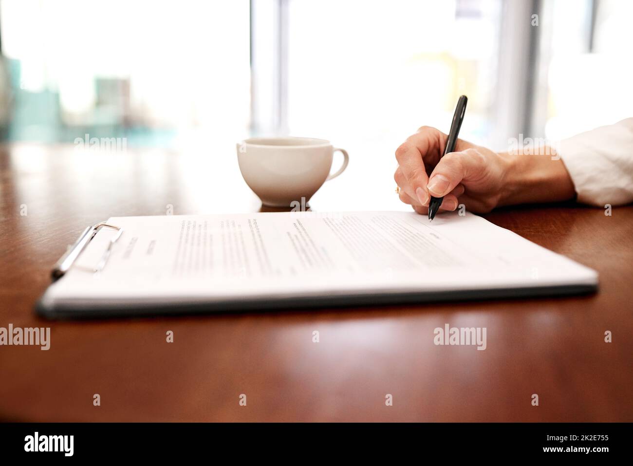 Mettre du papier au stylo sur une nouvelle proposition. Gros plan d'une femme d'affaires méconnue remplissant des documents administratifs dans un bureau. Banque D'Images