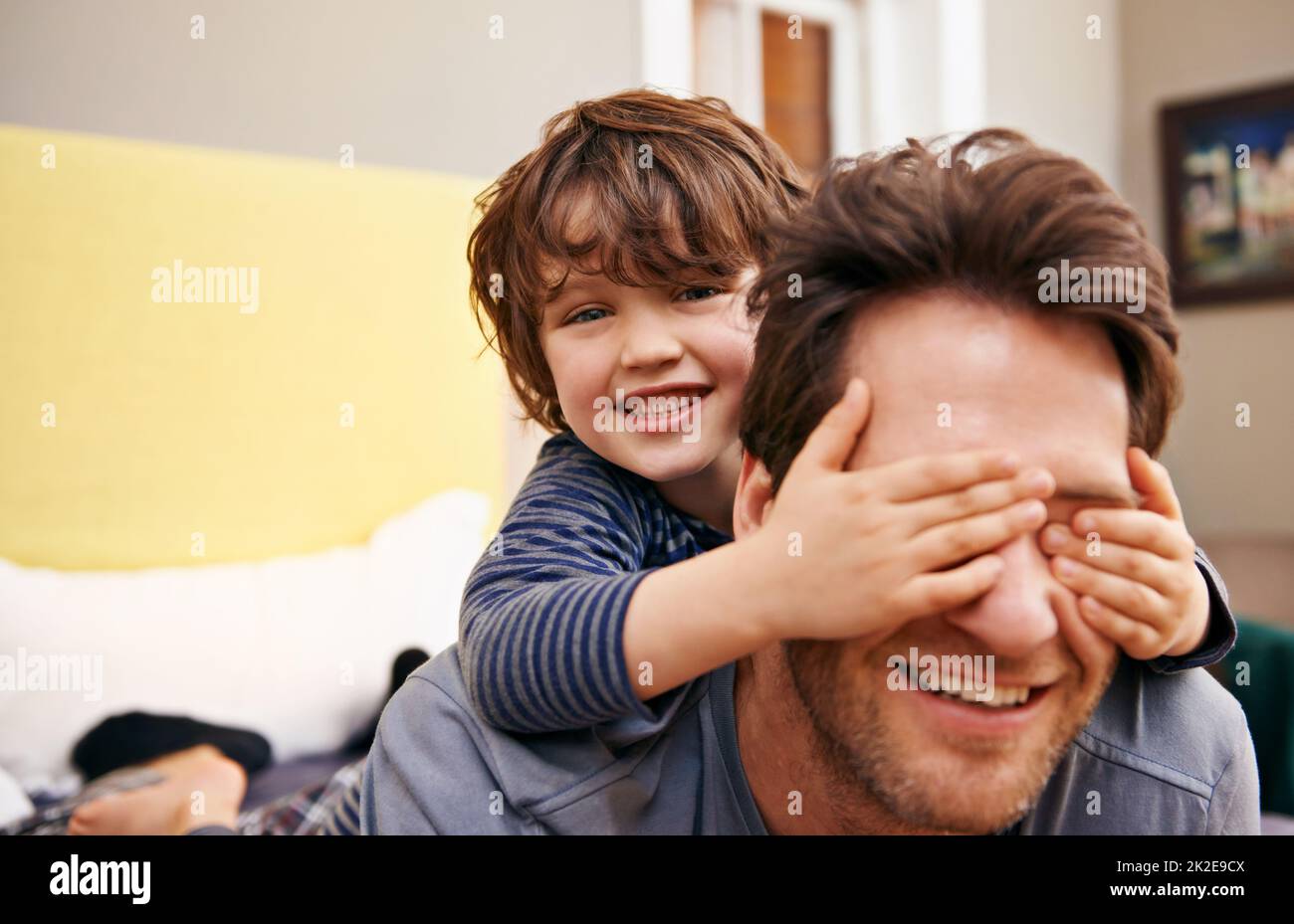 Père et son amusant. Photo d'un petit garçon couvrant les yeux de ses pères avec ses mains. Banque D'Images