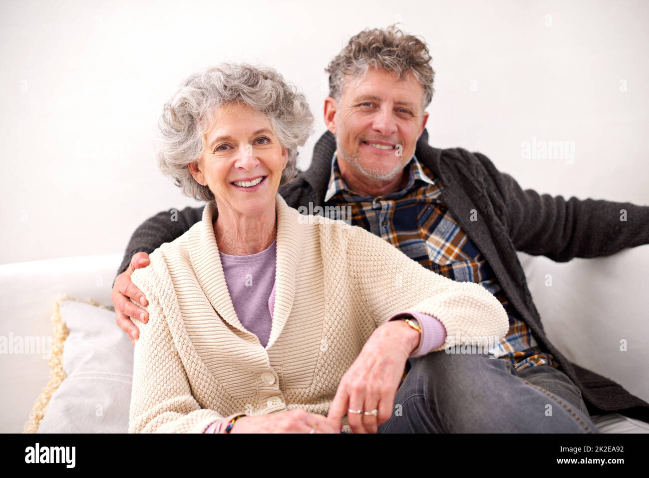 Passer leurs années d'or ensemble. Portrait d'un couple aîné aimant assis ensemble sur un canapé. Banque D'Images