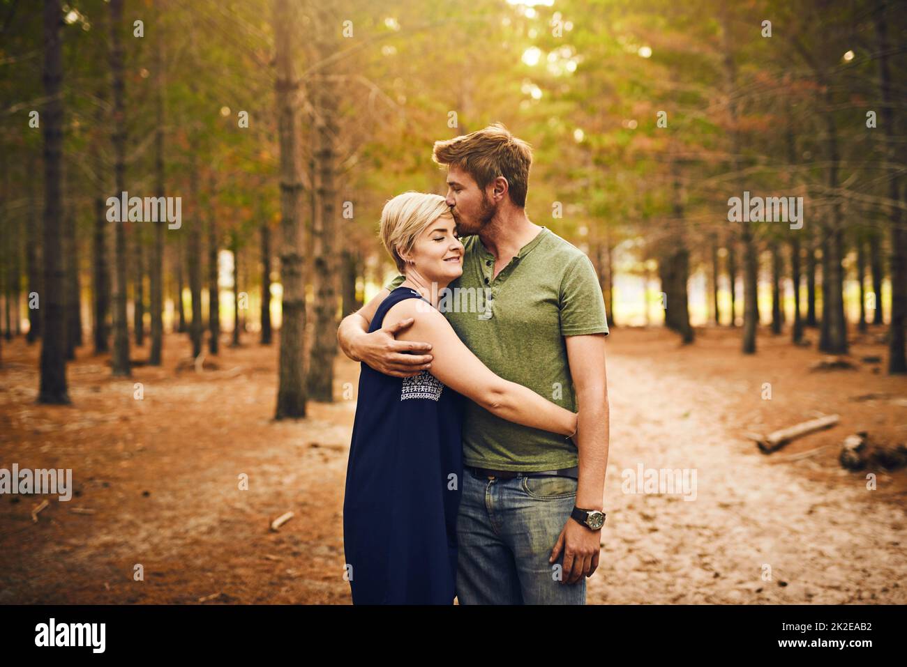 Nous sommes bénis d'être ensemble. Photo d'un couple aimant s'embrassant dans une hug tout en se tenant dehors dans les bois. Banque D'Images