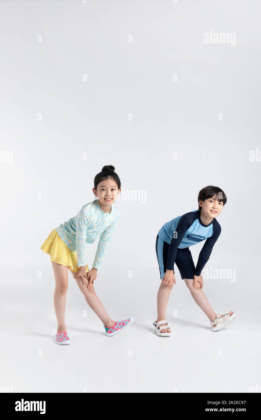 Coréen garçon et fille, concept d'été en fond blanc stretching avant de jouer dans l'eau Banque D'Images