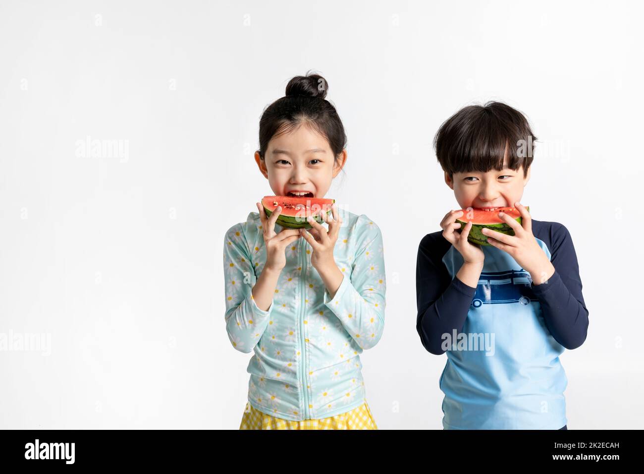 Coréen garçon et fille, concept d'été en fond blanc manger pastèque Banque D'Images