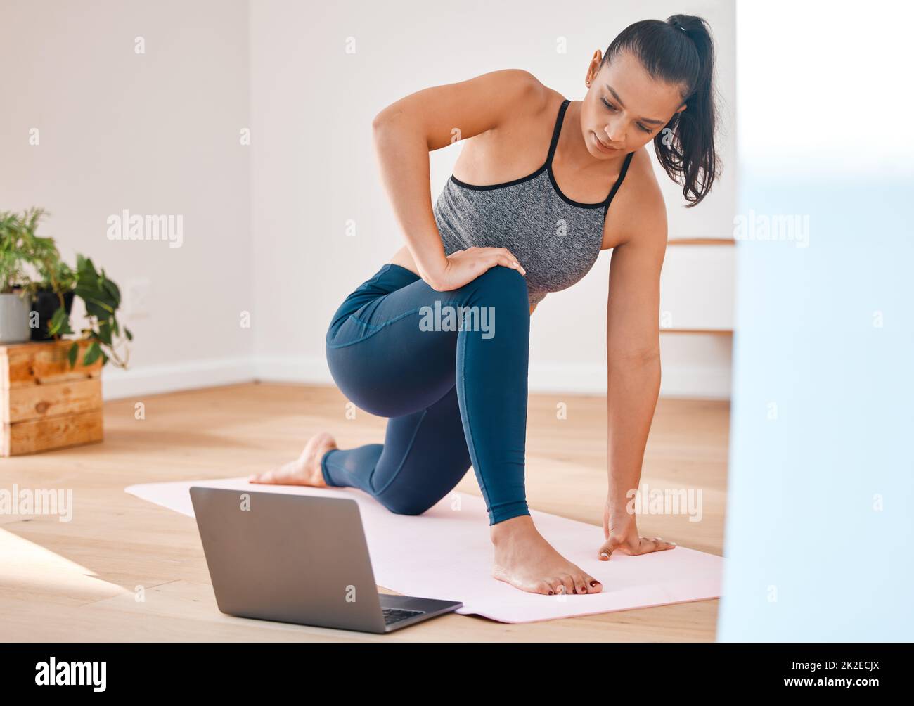 Soulagent le stress avec la forme physique. Photo d'une jeune femme pratiquant le yoga à la maison. Banque D'Images