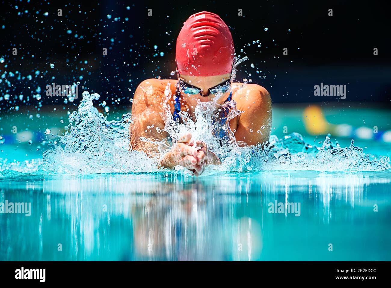 Le coup le plus dur en natation Photo d'une jeune nageuse qui effectue le mouvement du papillon. Banque D'Images