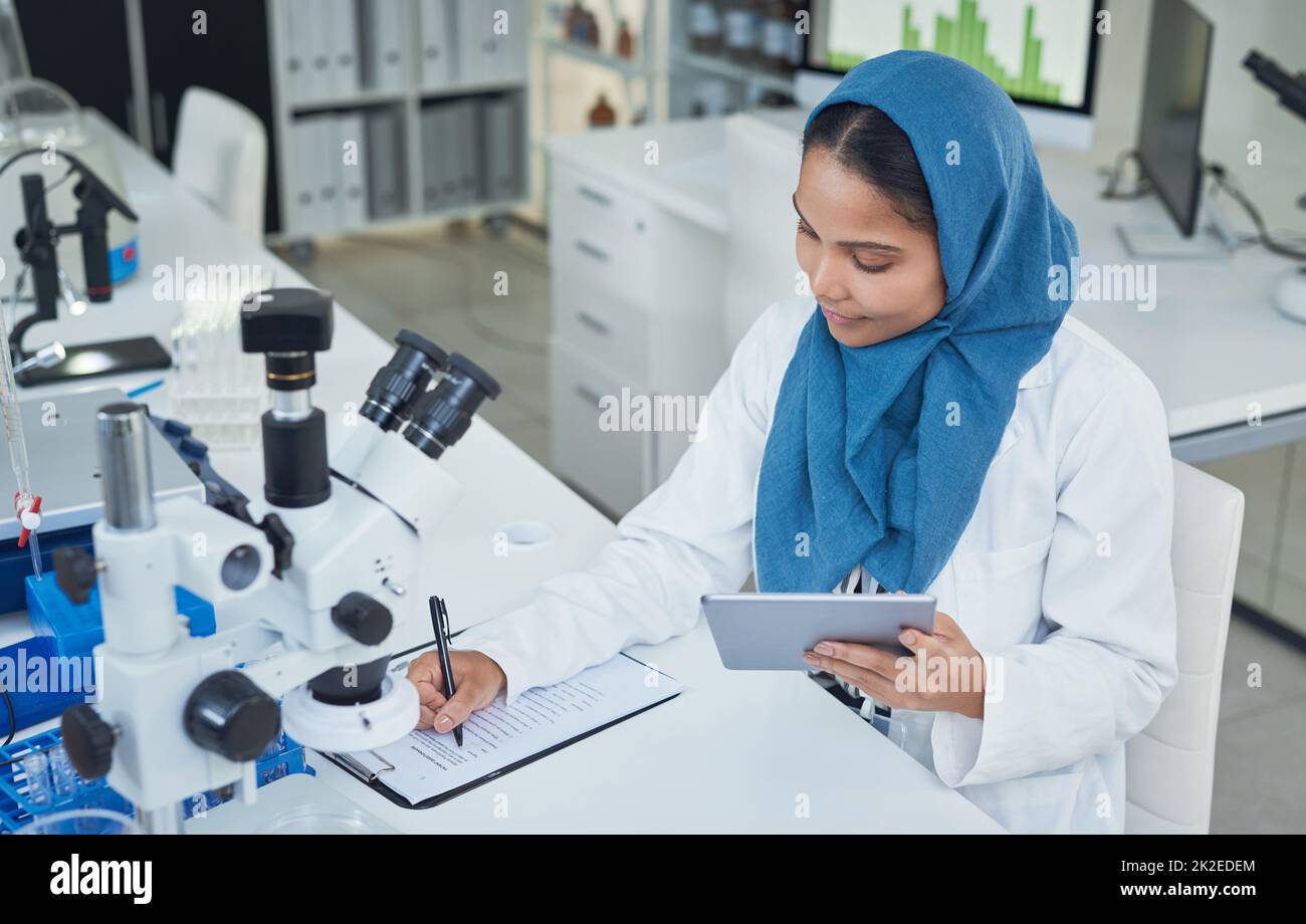 Travailler en laboratoire pour donner vie à vos activités. Photo d'un jeune scientifique utilisant une tablette numérique tout en effectuant des recherches dans un laboratoire. Banque D'Images