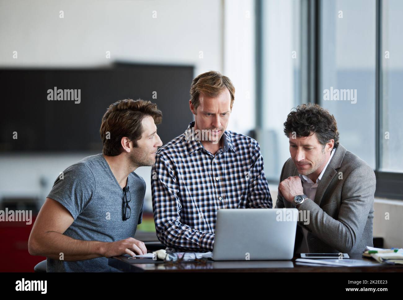 Que pensez-vous. Trois hommes d'affaires discutant du travail au bureau. Banque D'Images