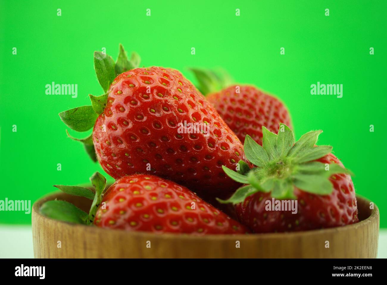 Fraises fraîches dans le jardin dans un bol en bois Banque D'Images