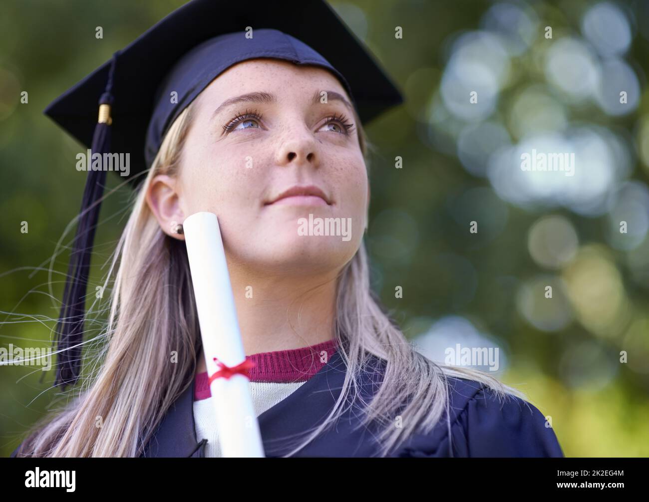 Penser à son avenir. Une femme diplômée titulaire de son diplôme. Banque D'Images