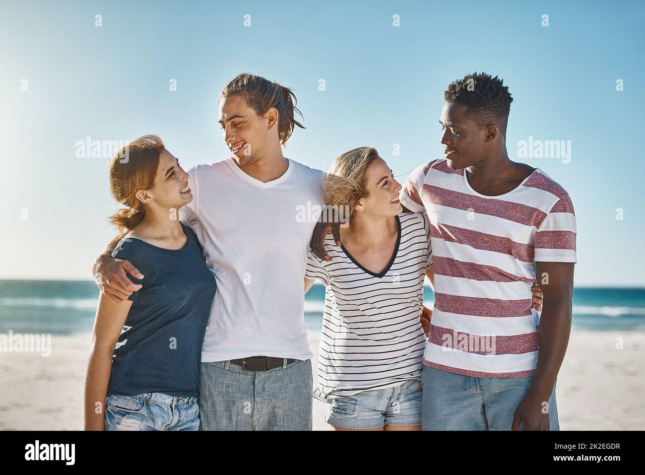 Pouvons-nous faire chaque jour un jour de plage. Photo d'un groupe de jeunes amis heureux posant sur la plage ensemble. Banque D'Images
