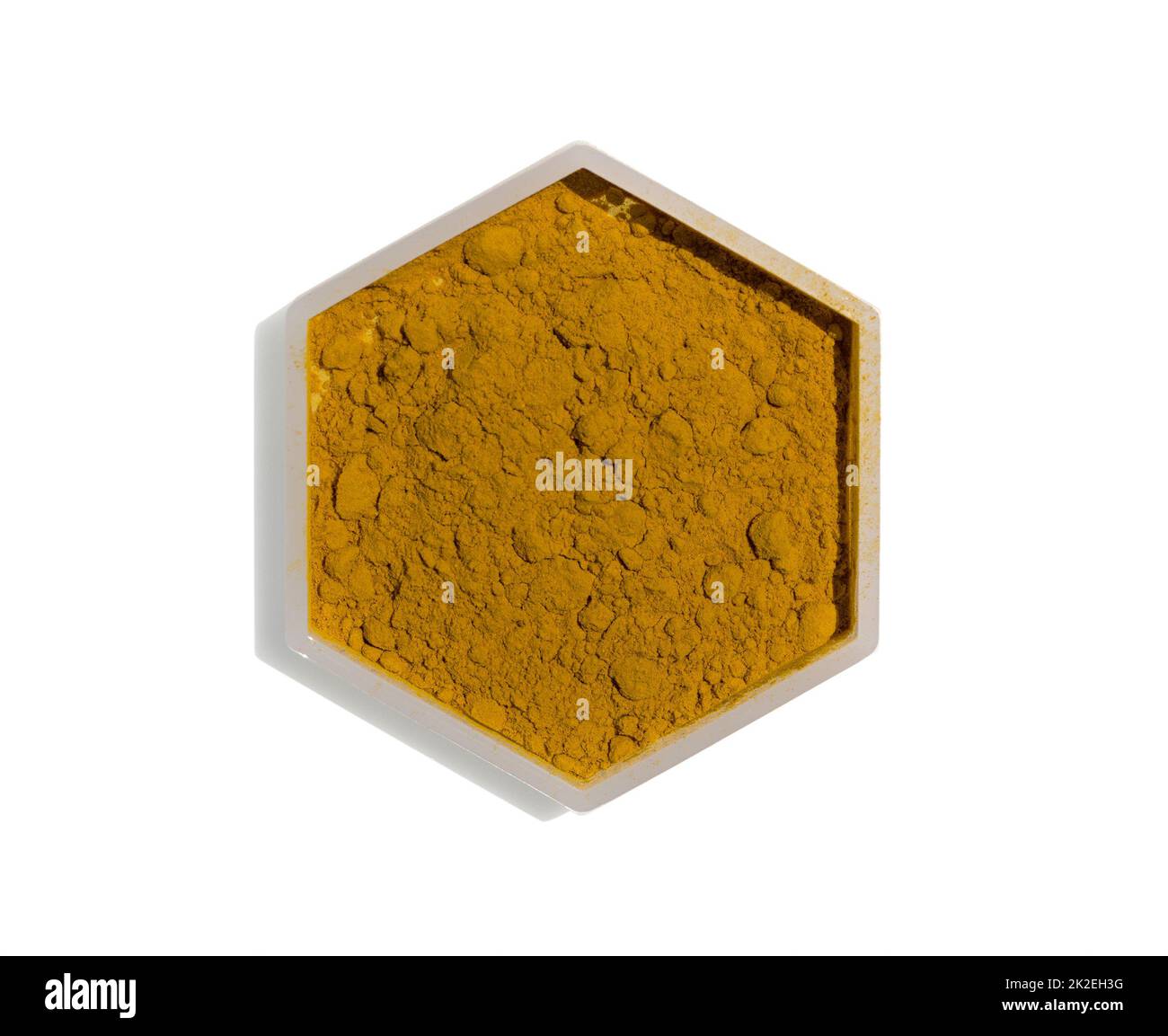 Poudre de curcuma organique dans un récipient hexagonal de forme moléculaire sur fond blanc. Banque D'Images