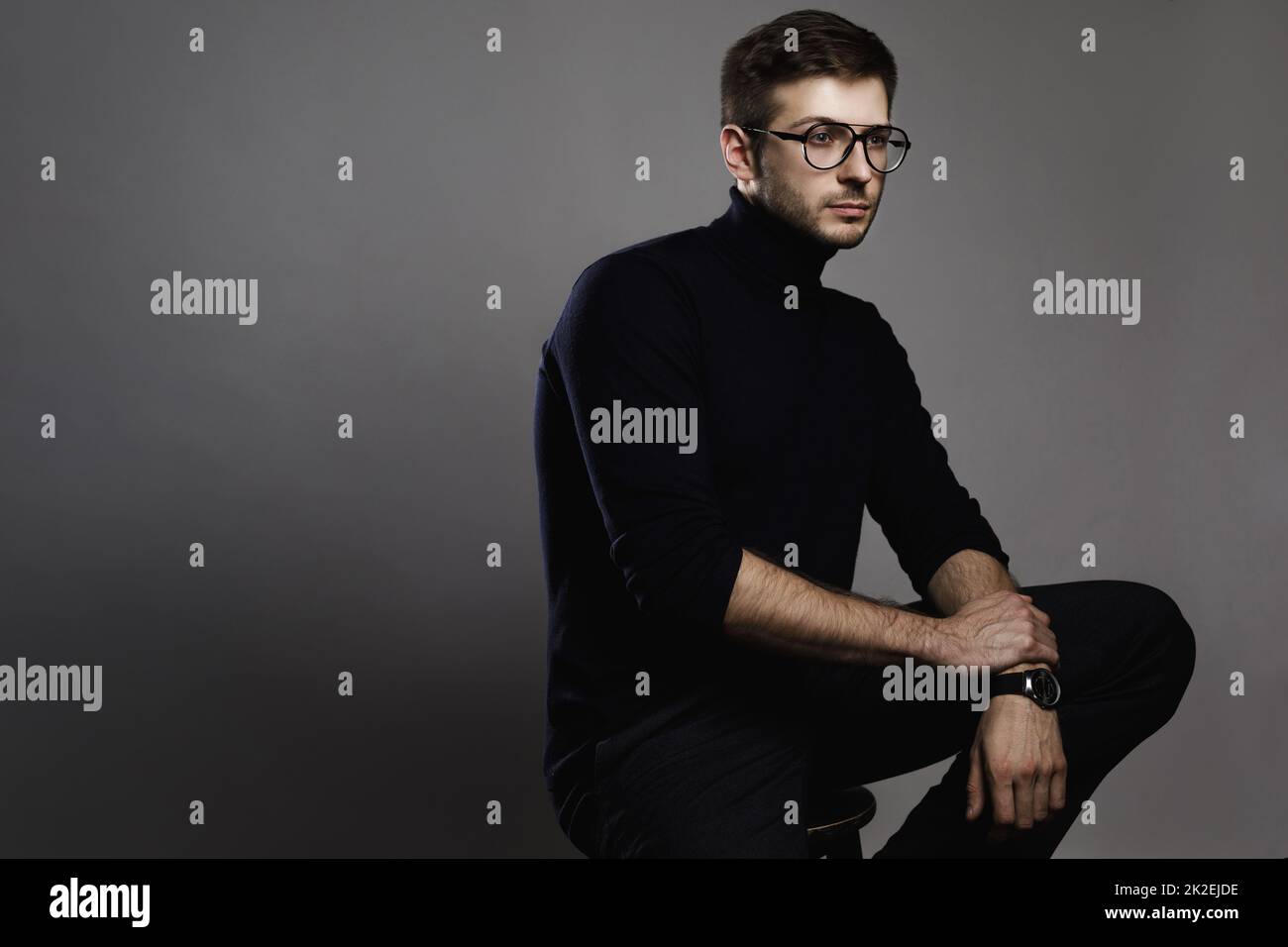 Jeune homme élégant portant des lunettes et un col roulé Banque D'Images