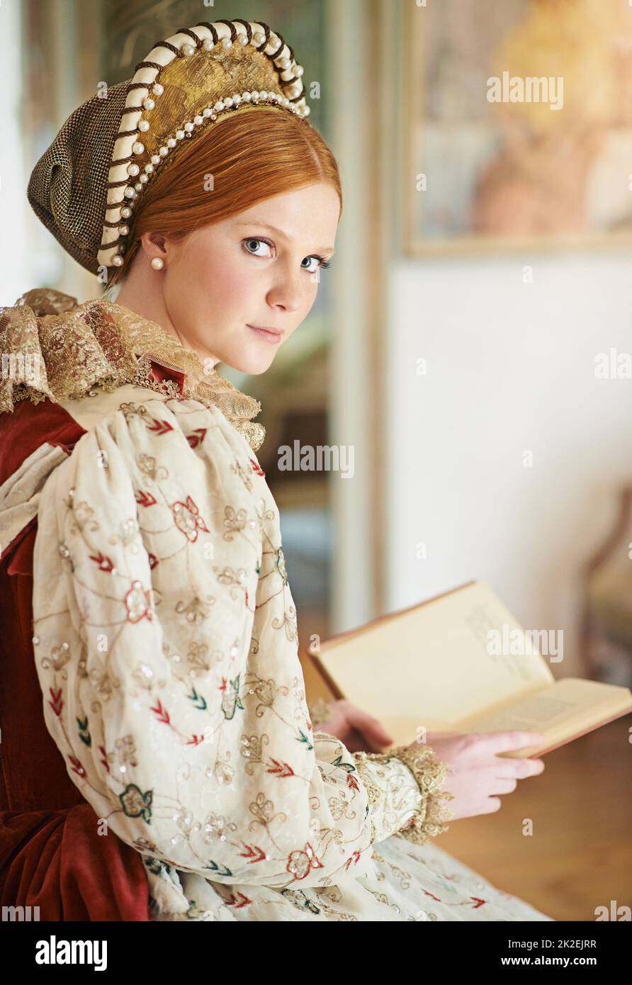 Seule dans ses chambres. Portrait d'une élégante noble femme lisant dans sa salle de palais. Banque D'Images