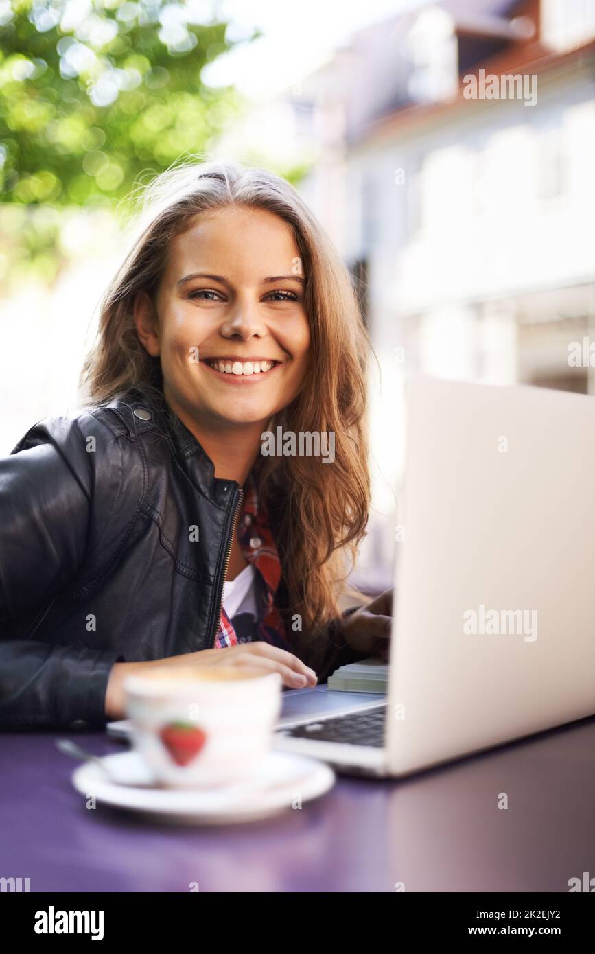 Profitez de la connexion wi-fi gratuite au bistro. Portrait d'un bel adolescent travaillant sur son ordinateur portable dans un bistro. Banque D'Images