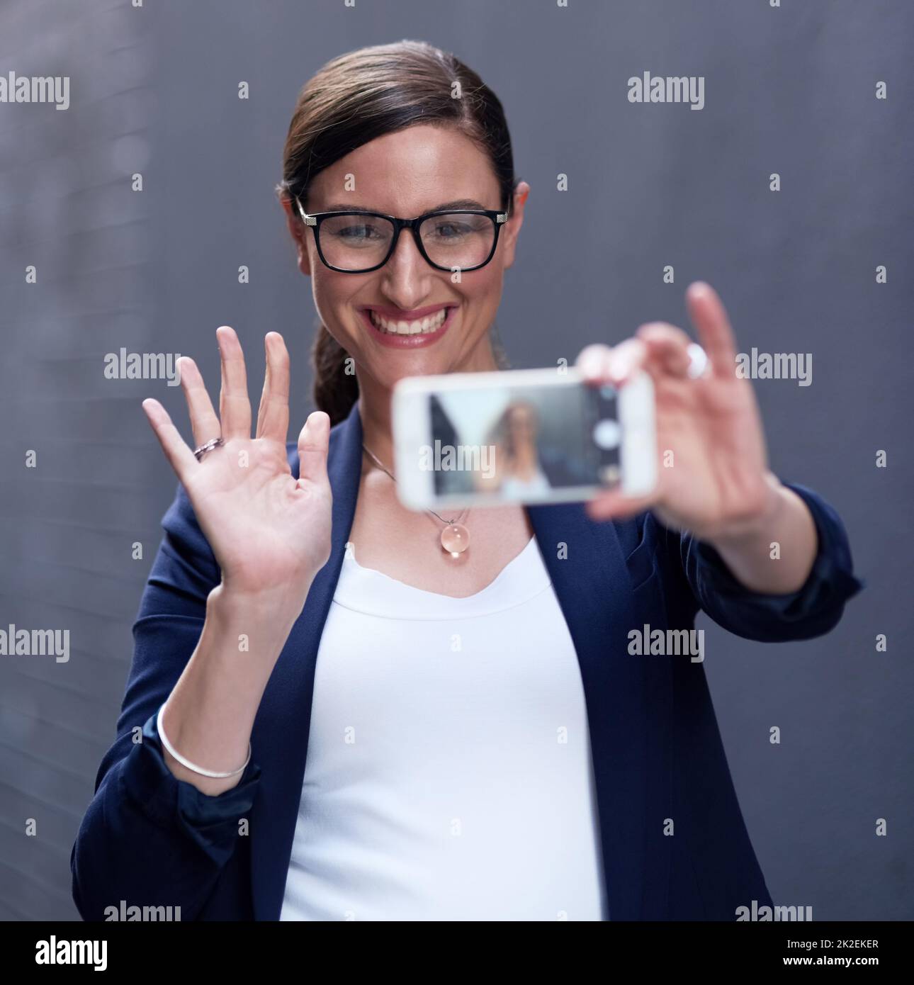 Bonjour, Bonjour tout le monde. Photo d'une femme d'affaires heureuse prenant un selfie amusant avec son smartphone. Banque D'Images