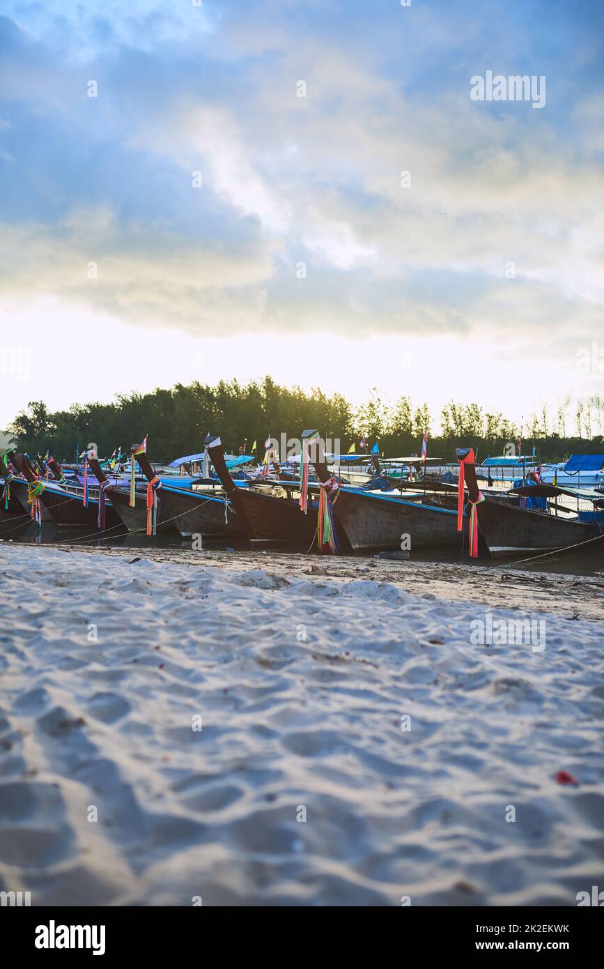 Chaque bateau a sa propre histoire. Photo de bateaux traditionnels en bois reposant sur une plage en Thaïlande. Banque D'Images