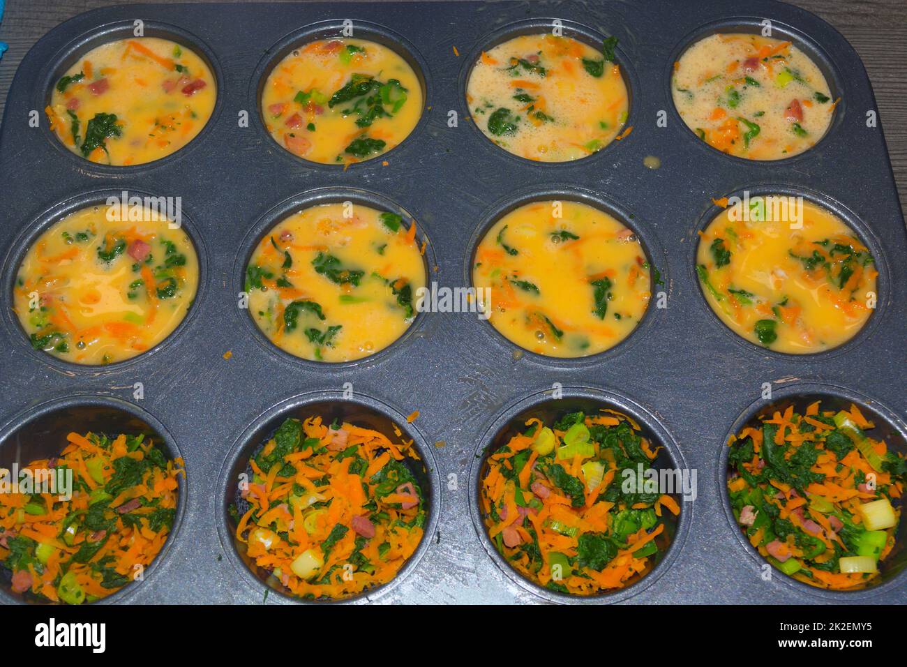 Muffins aux légumes frais dans un moule à muffins Banque D'Images