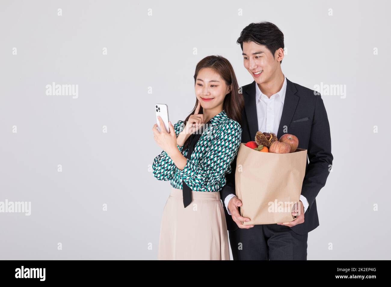 Jeune couple coréen, homme et femme portant un smartphone Hanbok Watching moderne Banque D'Images