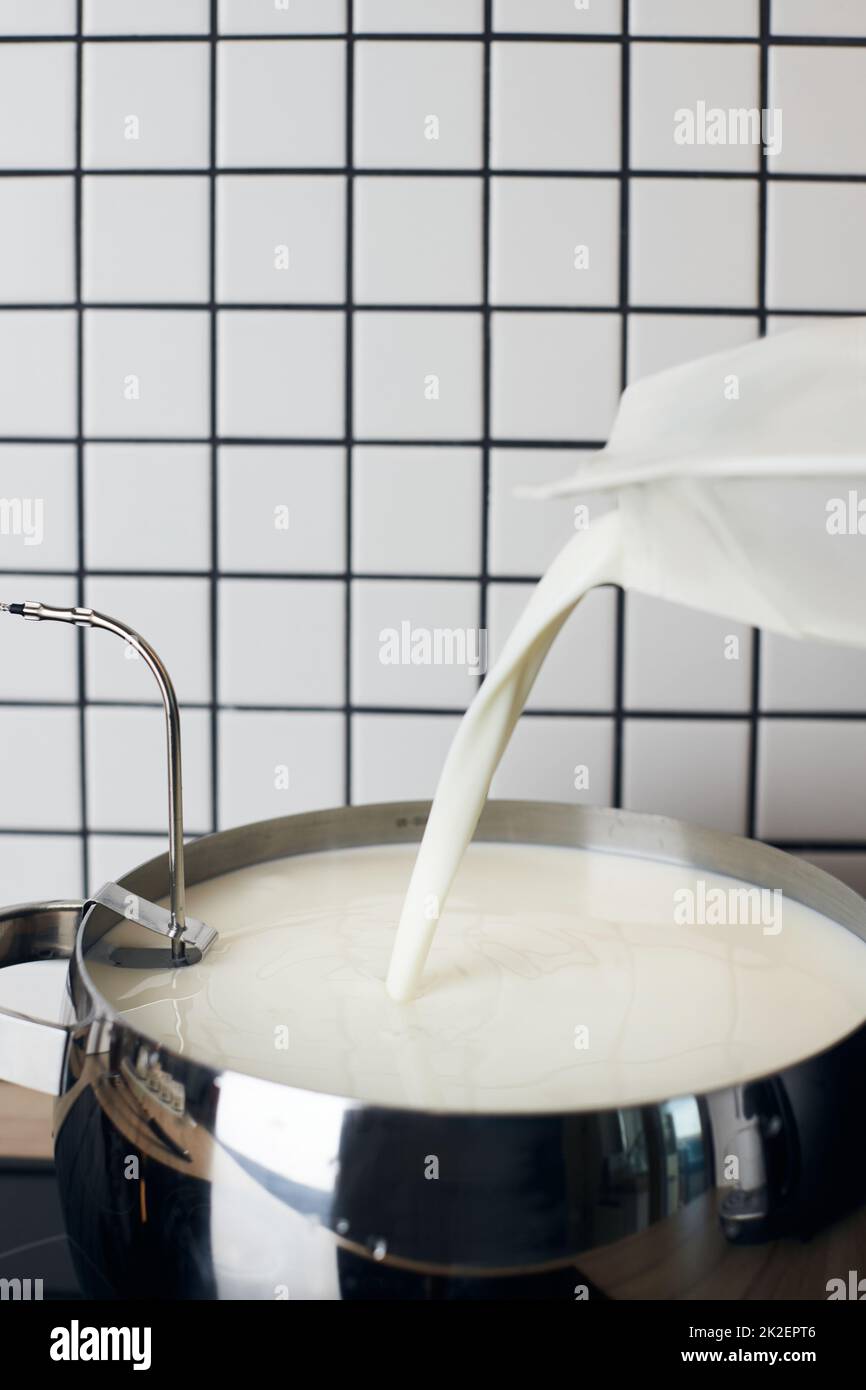 Le processus de fabrication de yaourt maison. Le lait est versé dans un récipient pour chauffer
