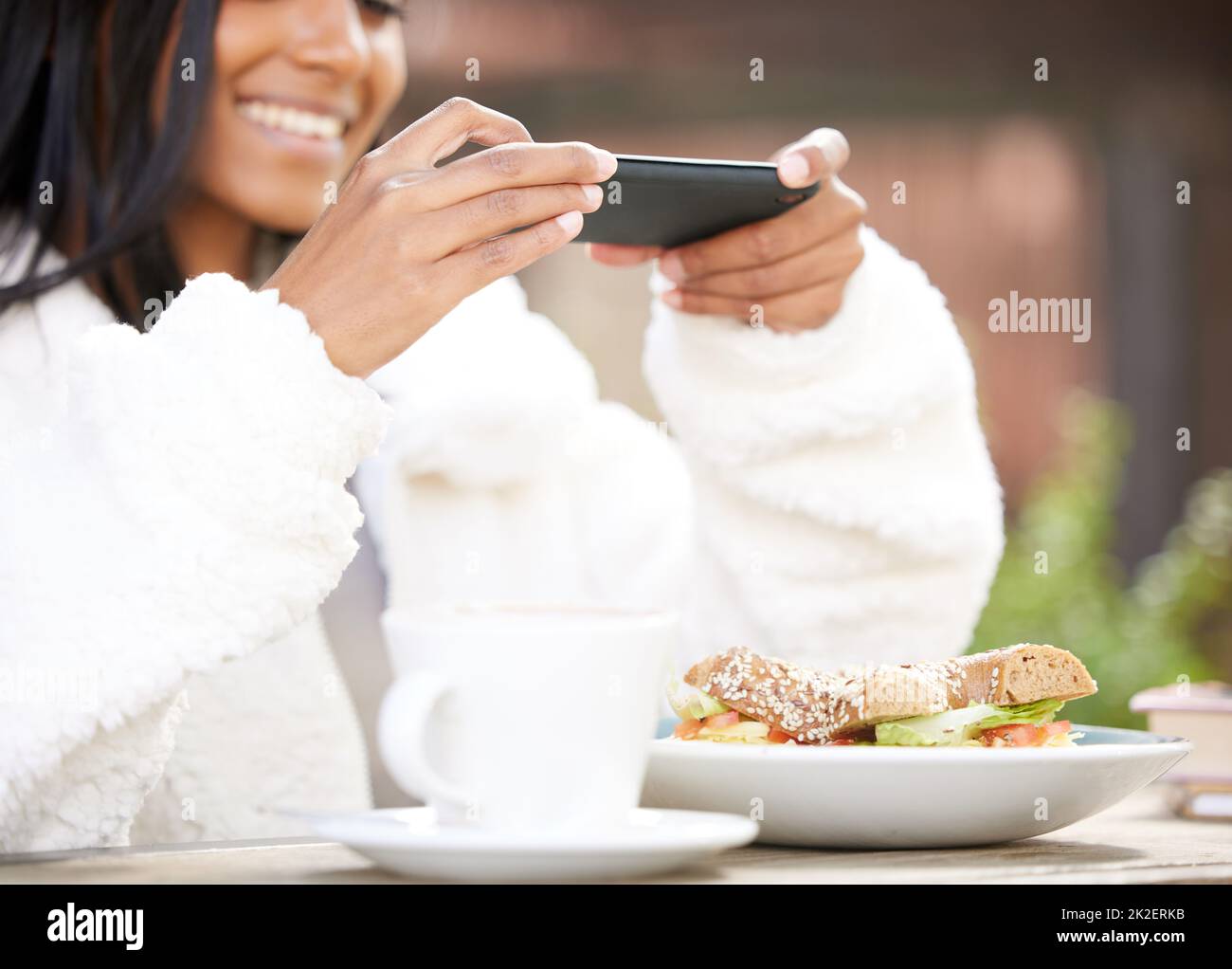 Je dois avoir une photo pour mes amis. Photo d'une jeune femme prenant une photo d'une assiette de nourriture. Banque D'Images