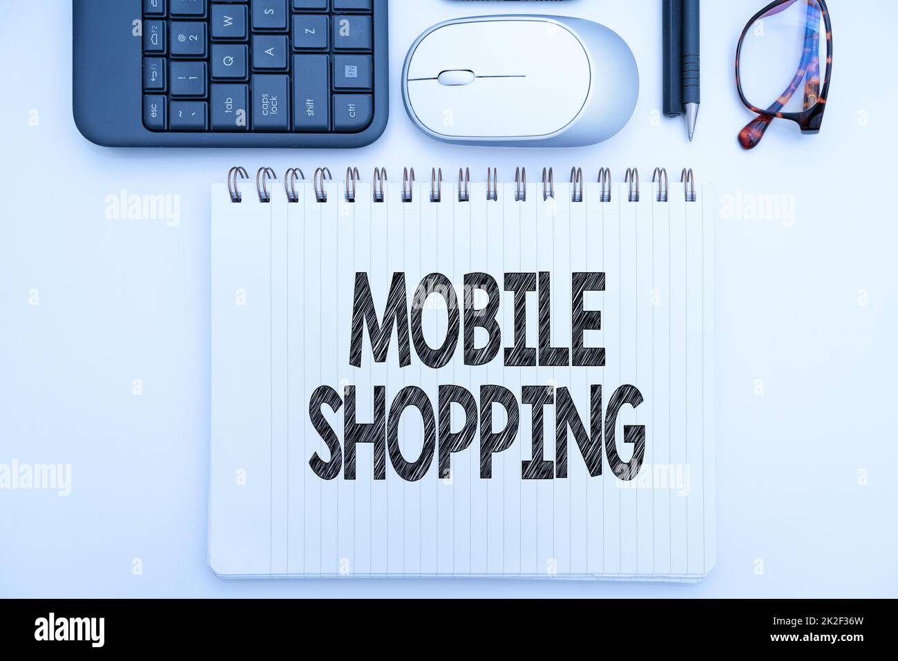Légende conceptuelle Mobile Shopping. Mot écrit sur l'achat et la vente de biens et de services par le biais de fournitures de bureau mobiles avec clavier et lunettes et tasse à café pour le travail Banque D'Images