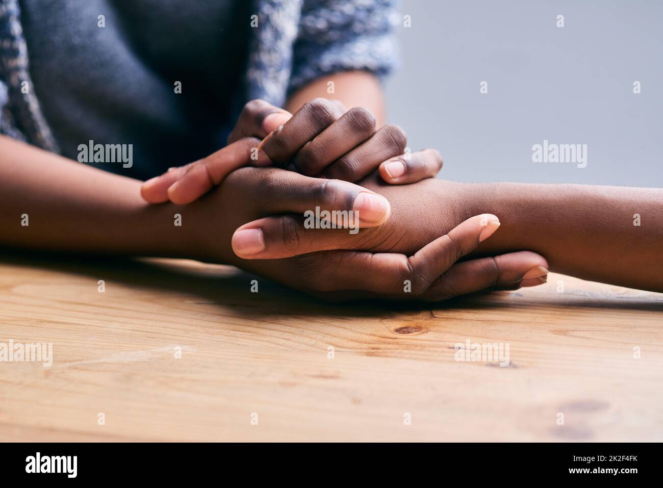 Soutenir un ami. Plan court d'une table de deux personnes tenant les mains confortablement. Banque D'Images